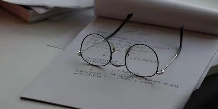 black framed eyeglasses on top of white printing paper