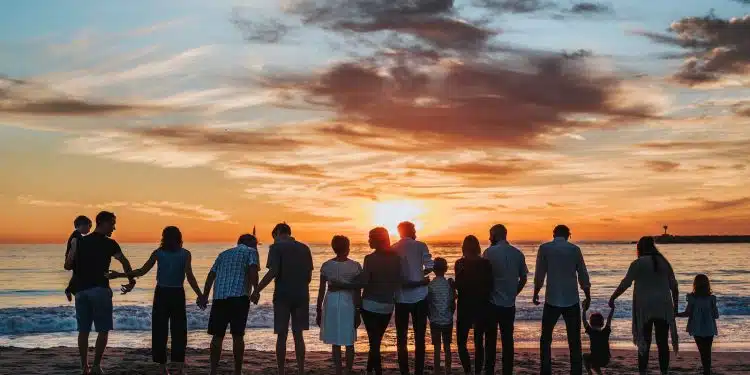 people standing on shore during golden hour