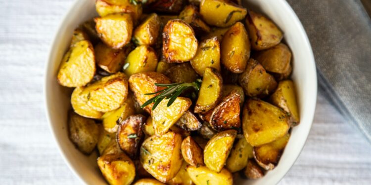 a white bowl filled with cooked potatoes on top of a table