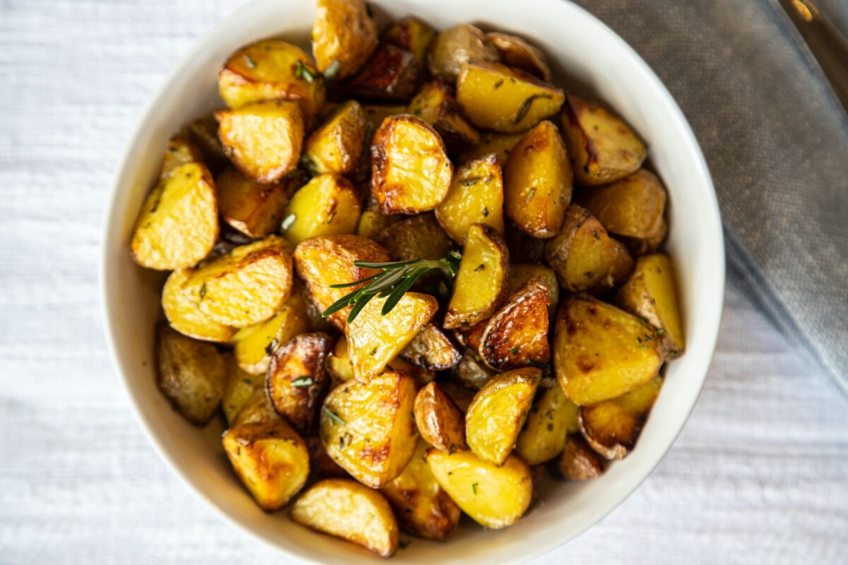 a white bowl filled with cooked potatoes on top of a table
